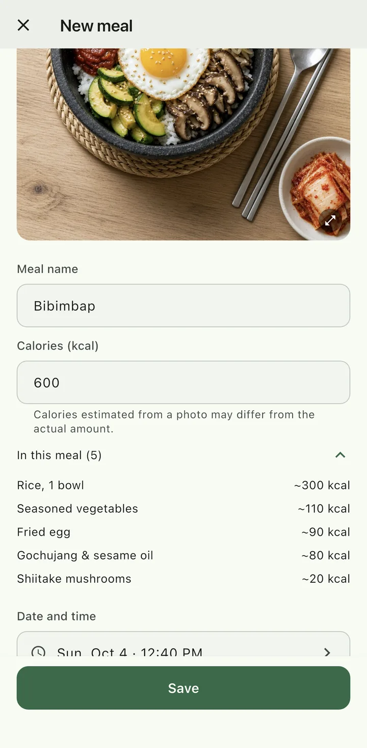 New meal screen after a photo estimate, sample data. Below a bibimbap photo: meal name ‘Bibimbap’, 600 kcal, a note that calories estimated from a photo may differ from the actual amount, and 5 items in this meal (rice ~300, seasoned vegetables ~110, fried egg ~90, gochujang and sesame oil ~80, shiitake mushrooms ~20 kcal).